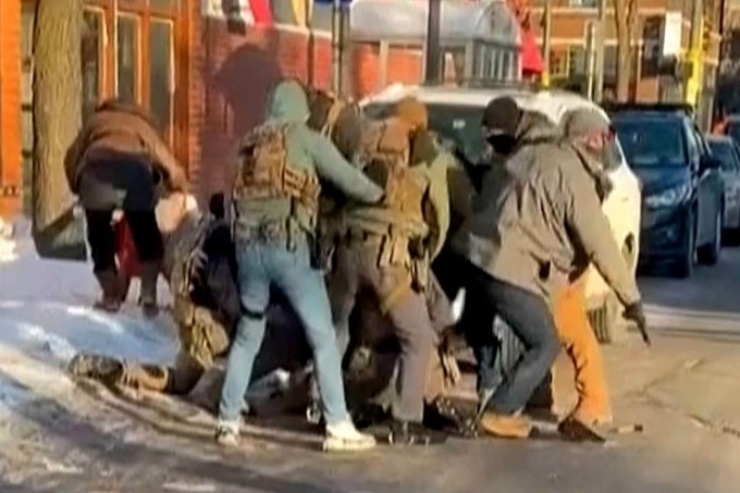 Đặc vụ mặc áo khoác xám (phải) cầm súng của Pretti rời đi. Ảnh: ABC News