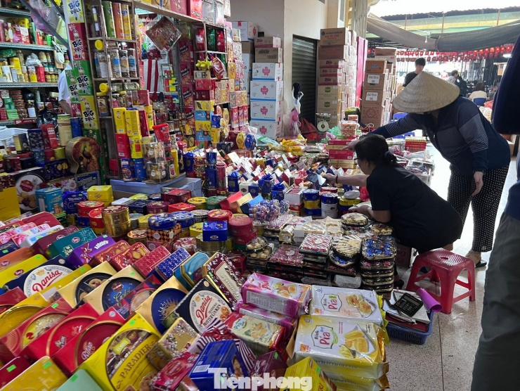 Các loại bánh kẹo ê hề, tiểu thương mỏi cổ ngóng khách. "Gần đây nhiều tiểu thương trả quầy sạp, ngừng kinh doanh ngay trong mùa kinh doanh sôi động nhất cả năm. Lý do nhiều quầy sạp chưa lắp đặt thiết bị công nghệ để kê khai thuế; nhiều tiểu thương lớn tuổi không quen với phần mềm kê khai thuế nên tạm thời ngừng kinh doanh. Tôi cũng không rành nên mỗi ngày đều ghi chép bằng tay, đến tối mới nhờ con cái nhập hộ" - một tiểu thương kinh doanh bánh kẹo nói.