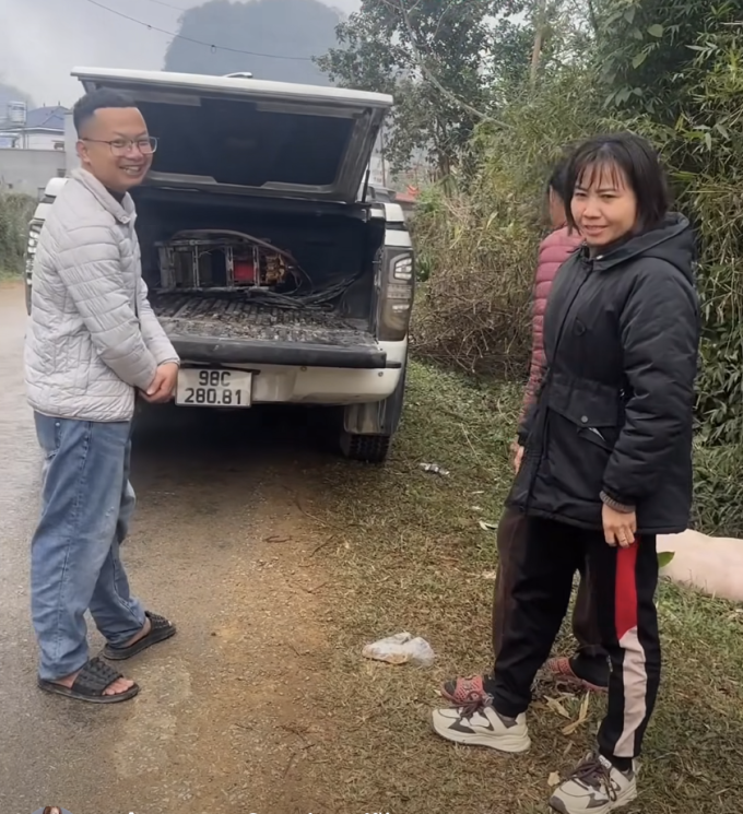 Chị Lương Ngâm (phải) trao trả lại con lợn nhảy khỏi thùng xe bán tải cho anh Thành Chung (trái) tại thôn Nam Hương 1, xã Vũ Lăng, trưa 24/1. Ảnh: Lương Ngâm