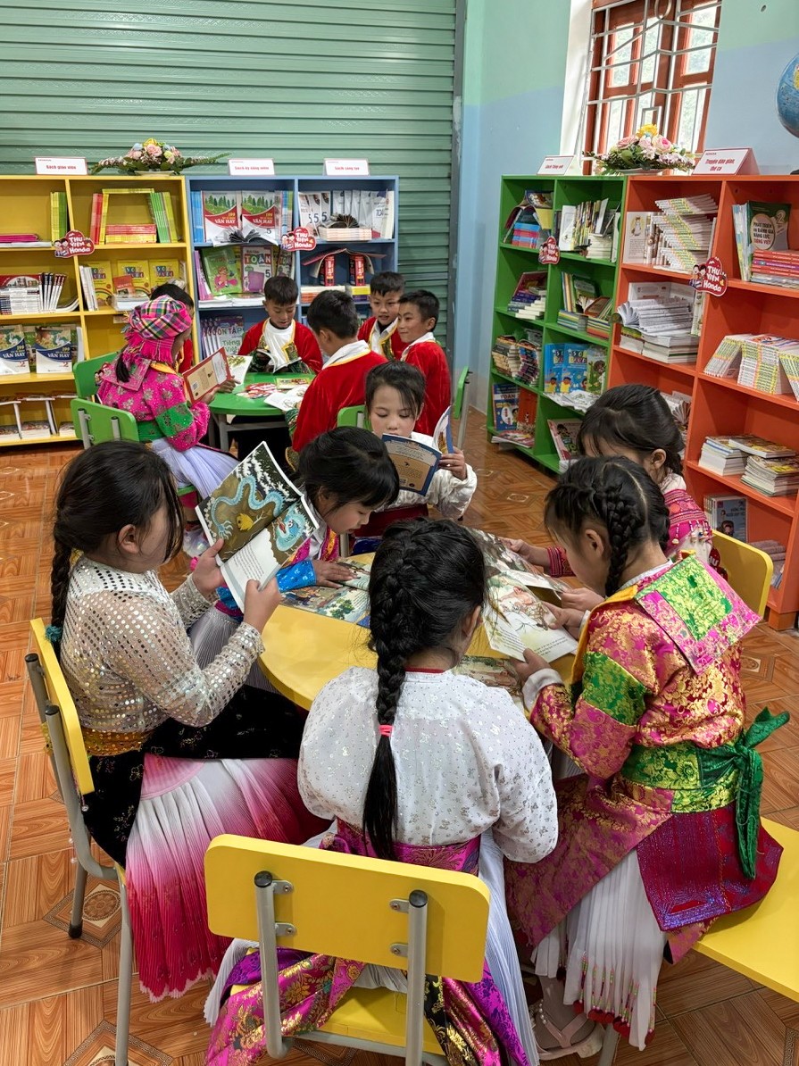 Các em học sinh trường Phổ thông Dân tộc Bán trú Tiểu học Pả Vi chăm chú đọc sách trong Thư viện Honda