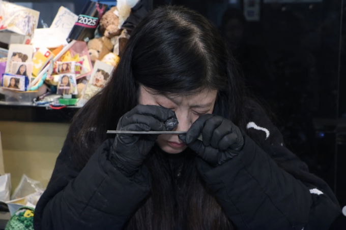 Thợ kim hoàn ở tại quận Jongno, trung tâm Seoul kiểm tra chất lượng bạc từ chiếc thìa được khách mang đến bán hôm 24/1. Ảnh: Channel A