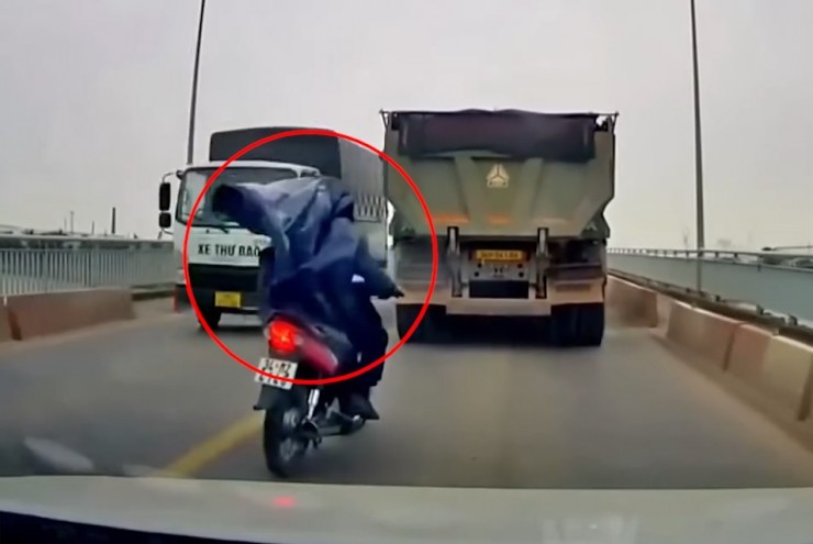 Clip: Áo mưa bị gió thổi trùm kín mặt, người đàn ông thoát chết trong gang tấc