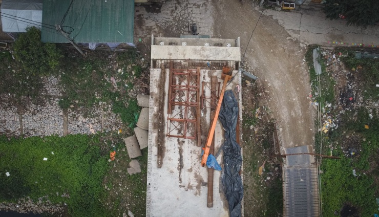 Trên công trường vật liệu chưa sử dụng nằm ngổn ngang, phủ bạt chờ thi công.