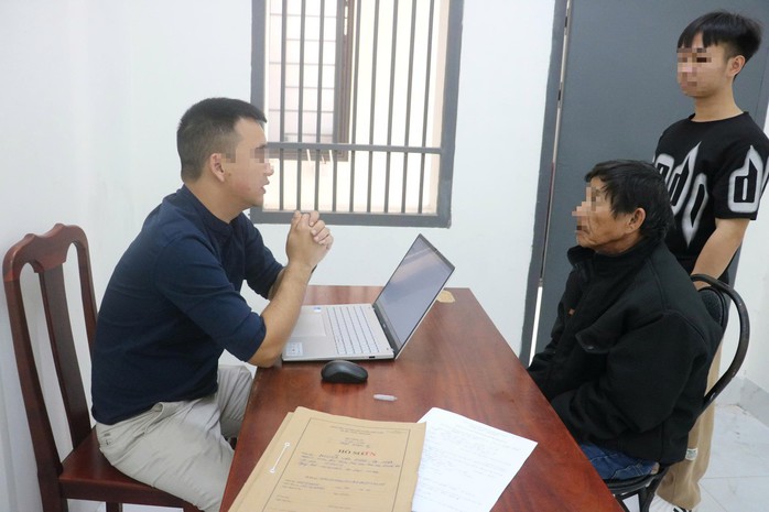 Nguyễn Văn Hùng (ngồi, bìa phải) tại cơ quan công an