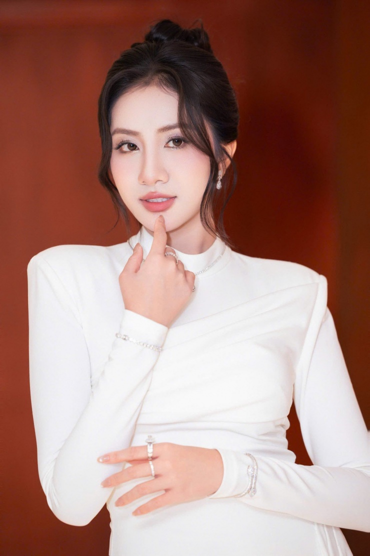 Hà Trúc Linh lựa chọn kiểu tóc búi cao gọn gàng, tôn lên đường nét gương mặt thanh tú. Người đẹp diện váy trắng ôm sát với đường xẻ tà cao, khéo léo khoe đôi chân thon thả cùng vóc dáng cân đối. Thiết kế tối giản nhưng tinh tế giúp nàng hậu ghi điểm bởi vẻ đẹp sang trọng, nữ tính mà vẫn hiện đại.