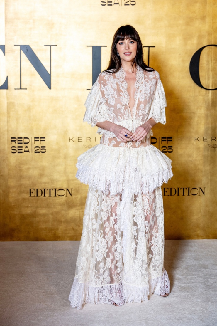 Khi tới dự Red Sea Film Festival ở Saudi Arabia tháng 12/2025, cô chọn bộ đầm ren peplum của Chloé. Dakota che chắn các khoảng hở bằng bodysuit màu nude. Ảnh: Reuters