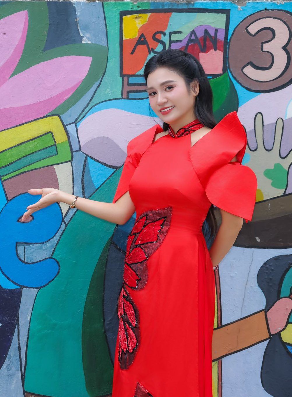 Trong một sự kiện, MC Thanh Mai chọn chiếc áo dài màu đỏ tươi rực rỡ với thiết kế tay bồng cách điệu từ cánh hoa sen tạo điểm nhấn nổi bật, mang đến vẻ đẹp hiện đại nhưng vẫn giữ được nét duyên dáng truyền thống của người phụ nữ Việt.&nbsp;