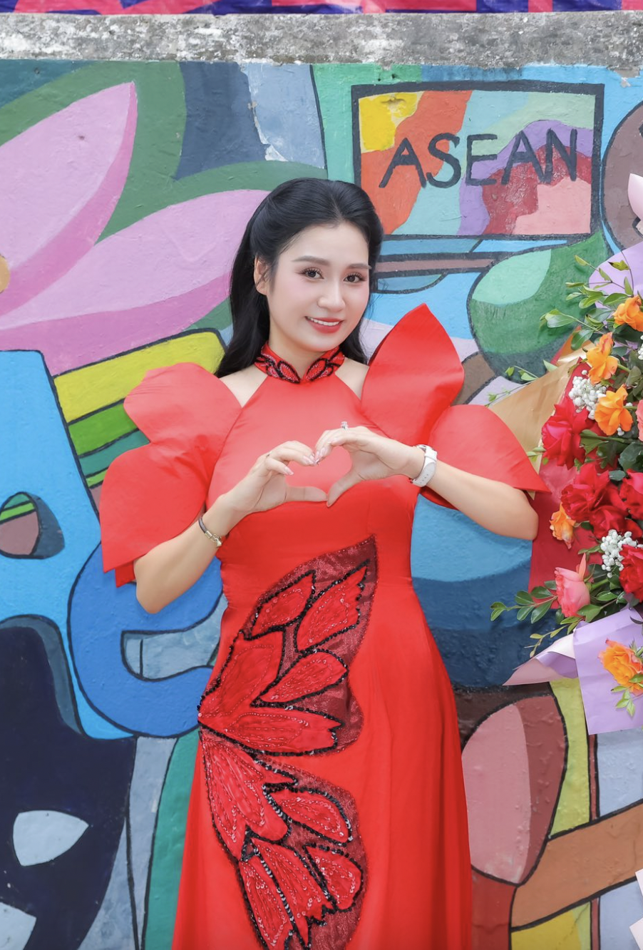 Trong một sự kiện, MC Thanh Mai chọn chiếc áo dài màu đỏ tươi rực rỡ với thiết kế tay bồng cách điệu từ cánh hoa sen tạo điểm nhấn nổi bật, mang đến vẻ đẹp hiện đại nhưng vẫn giữ được nét duyên dáng truyền thống của người phụ nữ Việt.&nbsp;