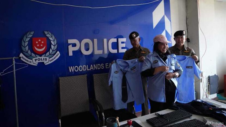 Một nhà báo Thái Lan mặc bộ đồng phục giả cảnh sát Singapore tại khu phức hợp lừa đảo ở O'Smach – Campuchia. Ảnh: AP