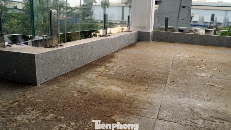 Mặc dù nhà đang thi công, chưa hoàn thiện nhưng khuôn viên ban công tầng 2 gia đình ông Quang bị phủ kín bụi màu. Dù ông và các thành viên có tẩy rửa nhiều lần, song lớp bụi bám chặt khiến gạch lát ban công bị xỉn, hoen ố.