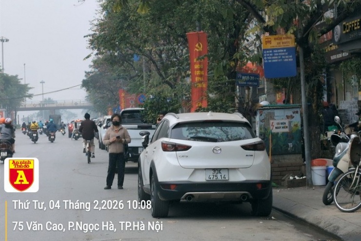 Hàng dài xe đỗ dưới lòng đường ở phố Văn Cao, chiếm dụng cả điểm dừng đón khách của xe buýt. Dịp cuối năm nhu cầu đi lại tăng cao, các phương tiện đỗ dưới lòng đường này sẽ ảnh hưởng lớn đến giao thông