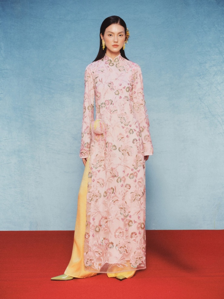 Primmy Trương diện áo dài của local brand Việt, giá khoảng 5 triệu đồng. Thiết kế sử dụng chất liệu vải tổng hợp dệt họa tiết kim sa, phối quần lụa, tạo cảm giác trang nhã.