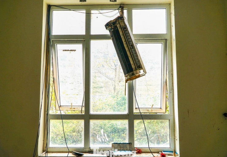 Máy điều hòa bị phá hoại, treo lơ lửng bên cửa sổ phía sau trung tâm hội nghị.