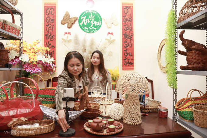 Chị Đặng Thị Kim Thêu, 42 tuổi, chỉnh góc máy, chuẩn bị livestream tại phòng trưng bày sản phẩm tại làng nghề mây tre đan Phú Túc (xã Phượng Dực), tối 22/1. Ảnh: Quỳnh Nguyễn