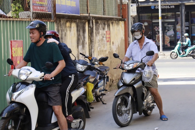 Phụ huynh Trường Tiểu học Nguyễn Văn Hưởng đưa cơm trưa cho con. Ảnh: Anh Nhàn