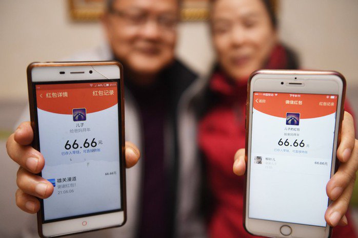 Một đôi vợ chồng tại TP Phúc Châu, tỉnh Phúc Kiến – Trung Quốc nhận lì xì điện tử từ con trai Ảnh: Tân Hoa Xã