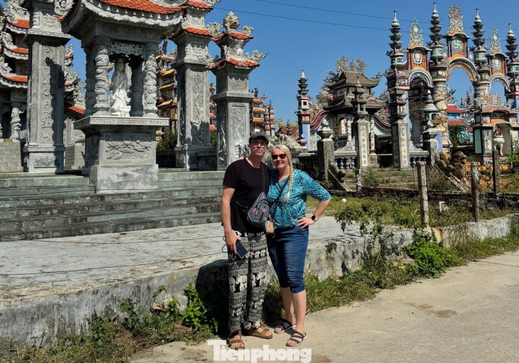 Hai du khách chụp ảnh kỷ niệm trước nghĩa trang An Bằng.