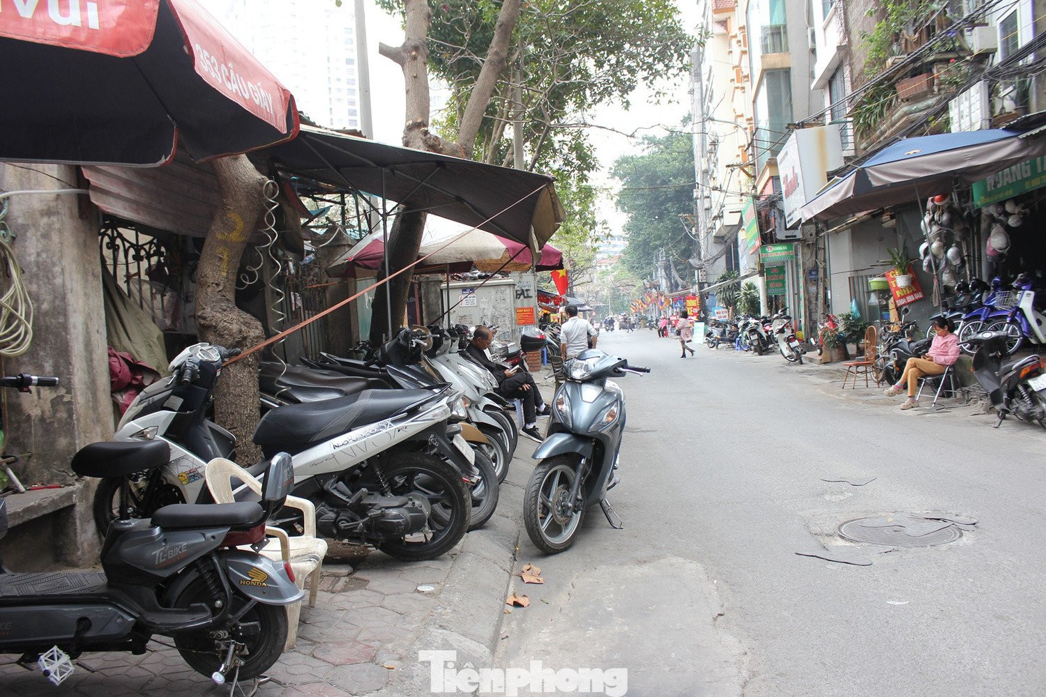 Dạo quanh một vòng chợ xe máy cũ tại phố Chùa Hà và khu vực lân cận như phố Nguyễn Khánh Toàn, Trần Đăng Ninh trong chiều 7/2 (20 tháng Chạp), không khó để bắt gặp hình ảnh những người thợ sửa xe máy, tiểu thương và cò xe ngồi túm tụm uống trà, cắn hạt hướng dương để "giết thời gian" vì vắng khách.