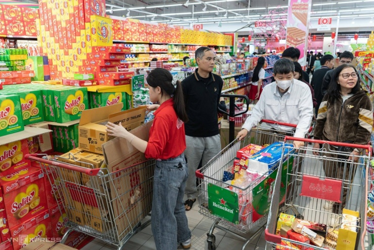 Khách hàng đẩy xe len lỏi chật kín các lối đi. Bà Nguyễn Thị Thu Hằng, Giám đốc siêu thị GO! Thăng Long (Hà Nội), tính toán lượng người đổ về mua sắm những ngày cuối tuần sát Tết sẽ đông gấp 3-4 lần ngày thường.