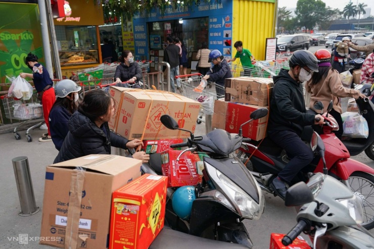 Tại bãi gửi xe, người dân gói đồ thành nhiều thùng giấy, cố định bằng băng dính, dây chun trước khi chuyển đi.