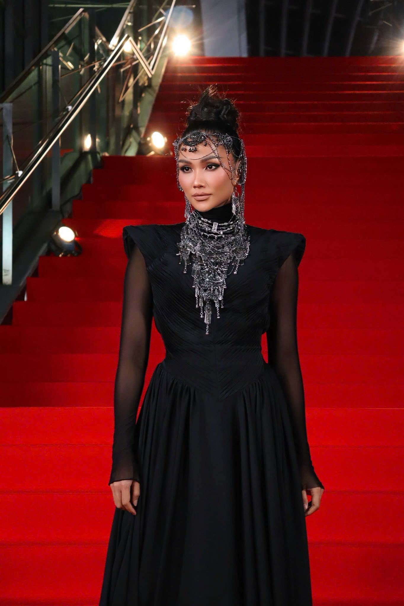 Hoa hậu H'Hen Niê bí ẩn với sắc đen và phụ kiện đội đầu lạ mắt trên thảm đỏ.