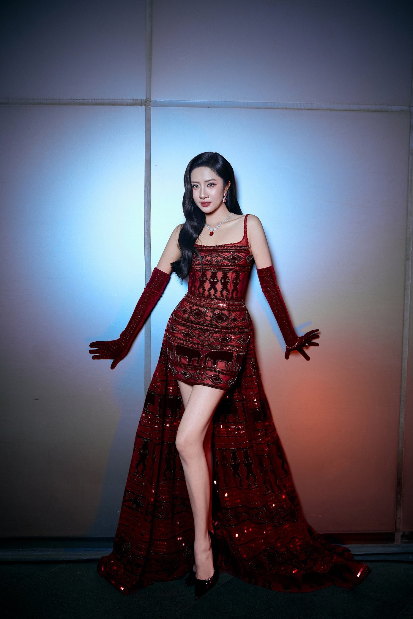 Người đẹp chọn phong cách trang điểm với son đỏ ấn tượng, uốn tóc xoăn bồng bềnh và đeo trang sức ton-sur-ton với màu váy để hoàn thiện vẻ ngoài.