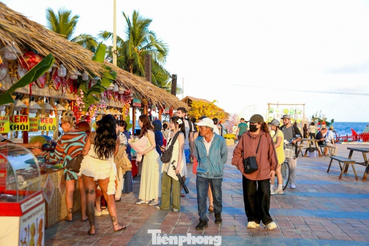 Theo ghi nhận, những ngày này, khu vực công viên Biển Đông (TP. Đà Nẵng) trở nên sôi động với sự tham gia của đông đảo người dân và du khách quốc tế. Nhiều du khách tỏ ra thích thú khi lần đầu trực tiếp tìm hiểu phong tục Tết Việt, từ gói bánh tét, làm mứt truyền thống đến thưởng thức các món ăn dân dã ngày xuân. Ảnh: Duy Quốc.