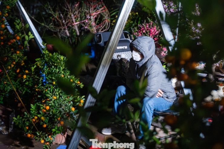 Càng về khuya, mưa phùn kèm gió lạnh khiến nhiệt độ giảm sâu, tiểu thương co ro, thu mình trong nhiều lớp áo ấm để chống lạnh.