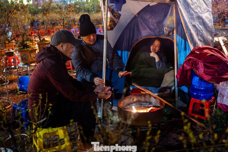 Bên bếp lửa bập bùng lúc 0h, bà Kim Anh (đường Lạc Long Quân) chia sẻ nỗi lo ế ẩm khi trời đổ mưa, cả ngày vắng bóng khách. Dù đã thức trông đào cả tuần nay, nhưng đây là những đêm khó khăn nhất khi vừa phải chống chọi với mưa rét, vừa thấp thỏm chờ người mua..