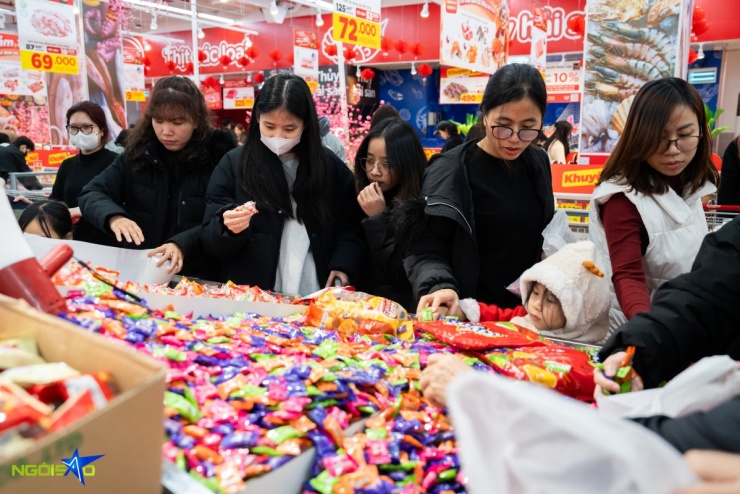 Tại khu vực bánh kẹo, đồ khô bán theo cân, lượng khách luôn đông kín. Nhiều mặt hàng được niêm yết giá cụ thể như kẹo dẻo xoài 18.000 đồng/100g; kẹo trà sữa trân châu, kẹo Alpenliebe caramel dâu đồng giá 12.000 đồng/100g; kẹo Sugus 17.000 đồng/100g; kẹo socola nhân sữa dừa 20.000 đồng/100g; kẹo đồng tiền có giá 26.000 đồng/100g...