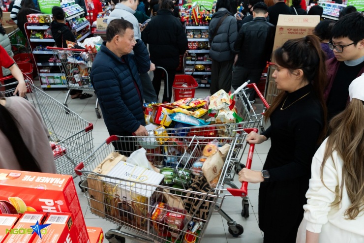 Nhiều xe đẩy chất kín thực phẩm nối dài tại khu vực chờ thanh toán.