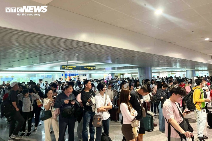 Bên trong ga đến quốc tế sân bay Tân Sơn Nhất, hàng nghìn kiều bào xếp hàng, chờ làm thủ tục nhập cảnh.