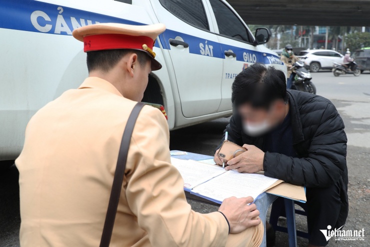 Tổ CSGT lập biên bản xử phạt với tài xế T. Ảnh: Đình Hiếu