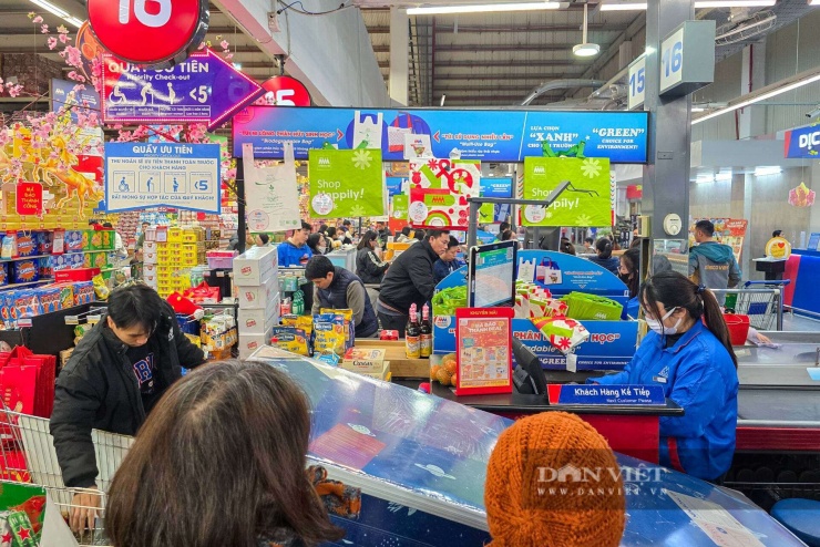 Tại Siêu thị MM Mega Market Thăng Long, mặc dù tất cả các quầy thu ngân đều đã hoạt động hết công suất, nhân viên làm việc không ngơi tay, nhưng hàng người chờ đợi vẫn nối đuôi nhau dài dằng dặc, uốn lượn qua các kệ hàng.