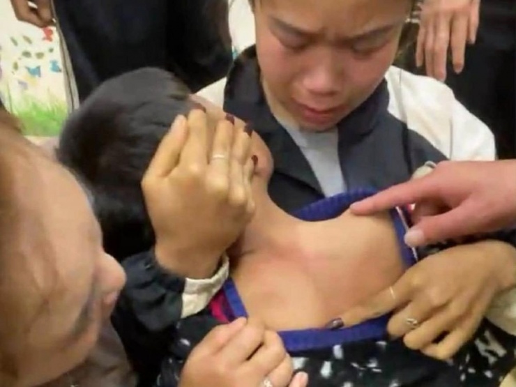 Gia đình kiểm tra người cháu bé sau sự việc. Ảnh cắt từ clip.