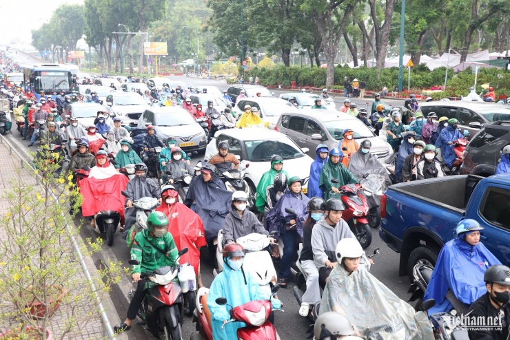 TPHCM mù mịt trong mưa trái mùa, người bán hoa 'ngồi trên đống lửa' ngày cận Tết - 3