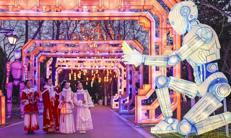 Học sinh tiểu học chụp ảnh bên chiếc đèn lồng robot hình người tại một lễ hội ở Hợp Phì, tỉnh An Huy, miền Đông Trung Quốc vào ngày 12/1. Ảnh: VCG