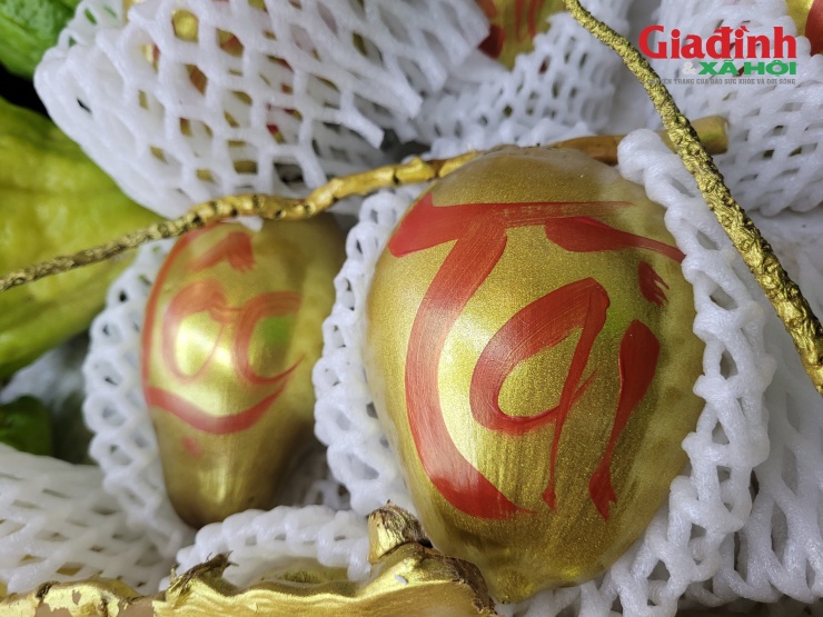 Cận cảnh sản phẩm dừa dát vàng với lớp vỏ phủ ánh kim bắt mắt cùng những dòng chữ thư pháp như "Tài", "Lộc", "Phúc"...