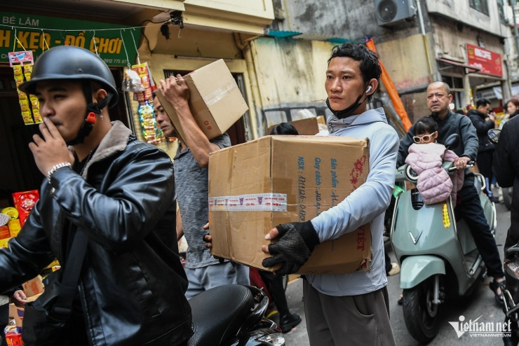 Nhiều người khệ nệ bê vác các thùng bánh kẹo. Shipper làm việc liên tục, chằng buộc hàng hóa nhích từng bước để đi. Không chỉ bận rộn với khách mua trực tiếp, các tiểu thương còn tất bật với những đơn đặt online.&nbsp;