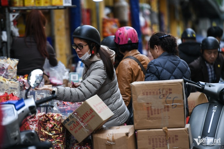 Tiểu thương liên tục nhập hàng, khách chen chân chọn lựa đồ ăn thức uống. Theo ghi nhận, giá bánh kẹo Tết tại phố Hàng Giầy không thay đổi nhiều so với ngày thường.&nbsp;