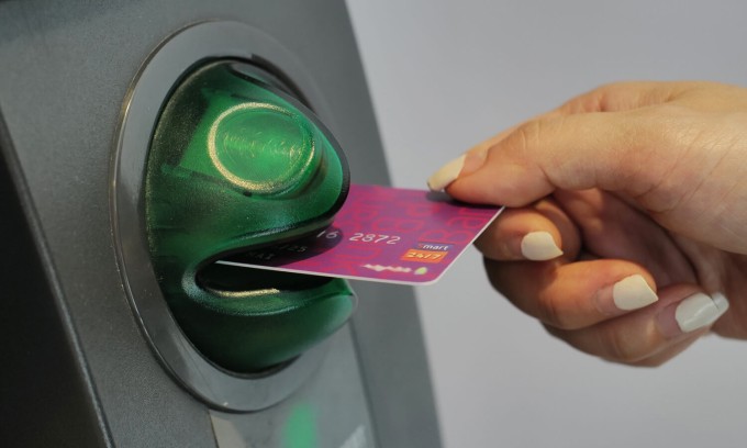 Một người đang rút tiền tại cây ATM. Ảnh: Ngọc Thành