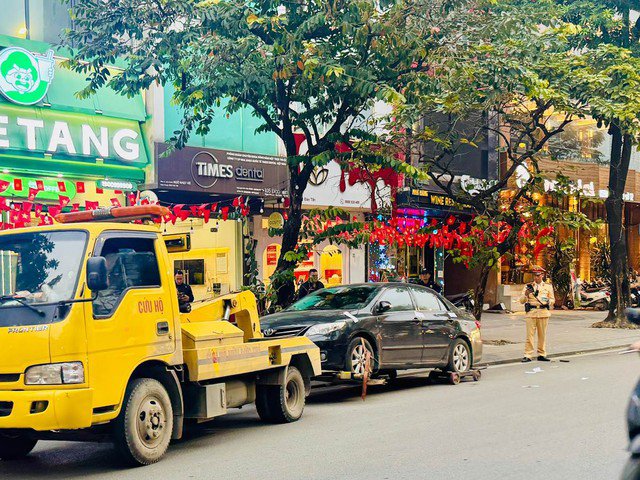Tổ công tác lập biên bản, niêm phong phương tiện và cẩu kéo khỏi khu vực vi phạm nhằm bảo đảm thông thoáng tuyến đường. Ảnh: Công an TP Hà Nội