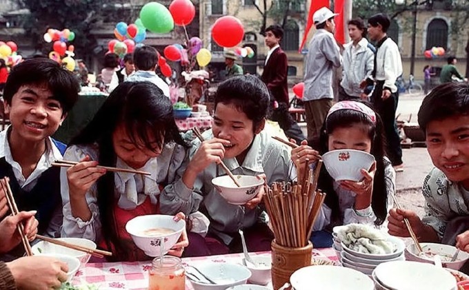 Nhóm học sinh du xuân, ăn phở trên khu vực phố cổ Hà Nội. Các quán ăn thường dùng loại khăn trải bàn nilon, phổ biến từ thời bao cấp.