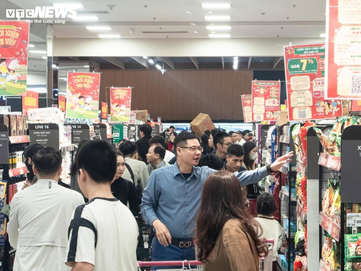 Theo ghi nhận, các siêu thị lớn, nhỏ hay các cửa hàng tiện lợi bán đồ dùng, thực phẩm Tết đều chật như nêm. Dù trước đó, các quầy đều đã được bổ sung đầy hàng nhưng hiện đã vơi đi rất nhiều.