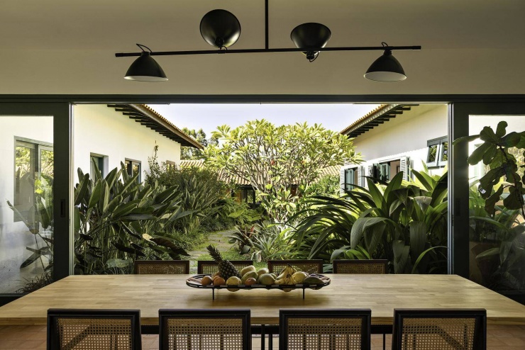 Góc nhìn từ bàn ăn hướng ra sân trong, nơi thiên nhiên ùa vào nhà qua hệ cửa mở rộng. Nguồn: Archdaily