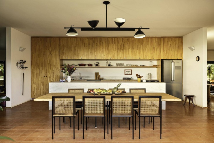 Căn bếp hiện đại với hệ tủ gỗ và đảo bếp bằng đá cẩm thạch trắng sang trọng. Nguồn: Archdaily