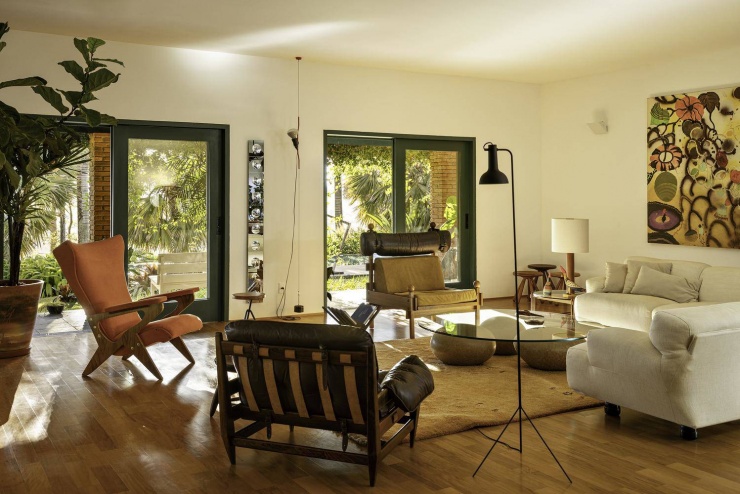 Một góc thư giãn đầy phong cách với chiếc ghế bành màu cam đất ấn tượng. Nguồn: Archdaily