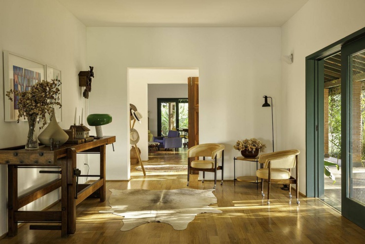 Khu vực sảnh đón với bàn gỗ mộc mạc và các vật dụng trang trí tinh tế. Nguồn: Archdaily
