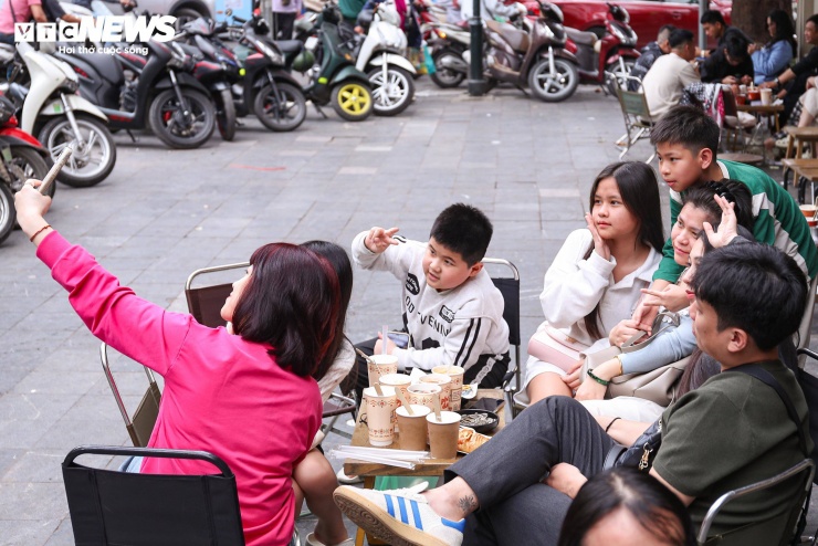 Một gia đình lưu lại khoảnh khắc bên nhau tại quán cà phê trong ngày cận Tết.