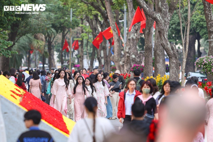 Tại khu vực Hồ Gươm, hàng trăm cô gái diện áo dài rực rỡ, tranh thủ lưu lại những khoảnh khắc trước thềm năm mới.